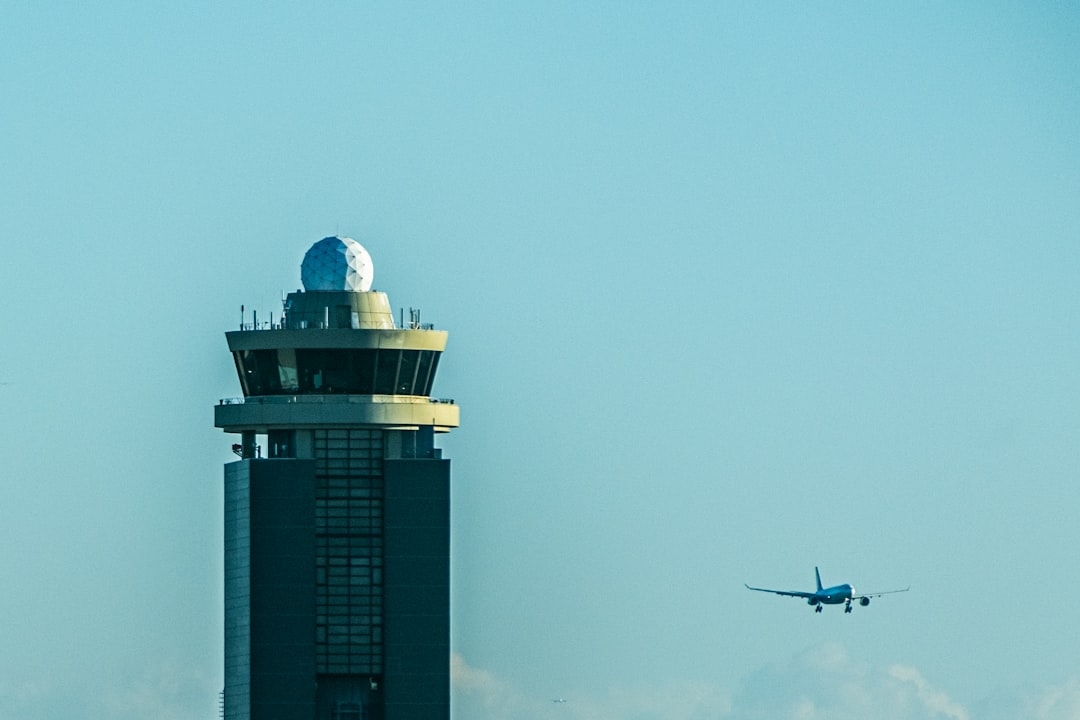 a-plane-flying-over-a-tall-tower-b7e9f8-swj4